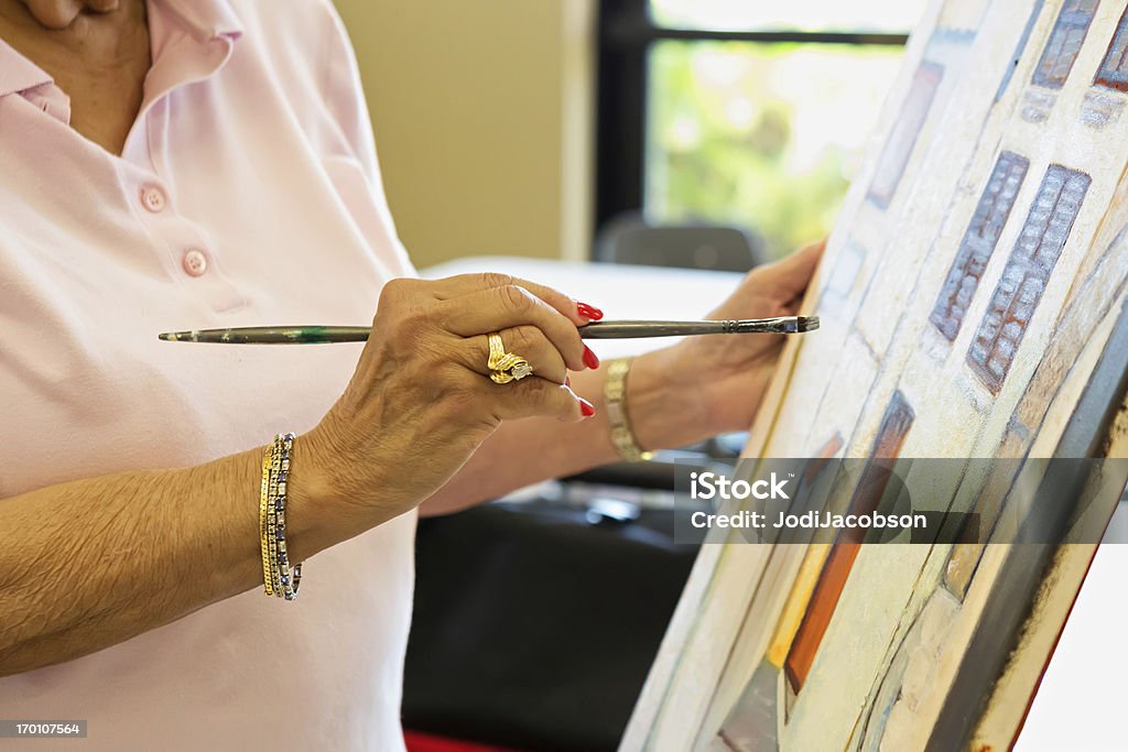 Senior woman in art class Senior woman in a 55 and over community in an art class offered as a activity for residents.  rr Active Seniors Stock Photo