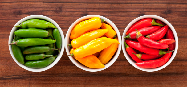 Three bowls with chili peppers of different colors