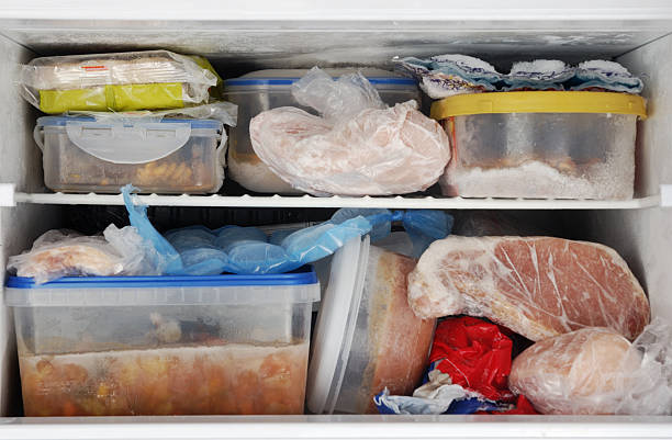 Freezer Frozen food inside a freezer. Lots of leftovers in plastic containers. leftovers photos stock pictures, royalty-free photos & images