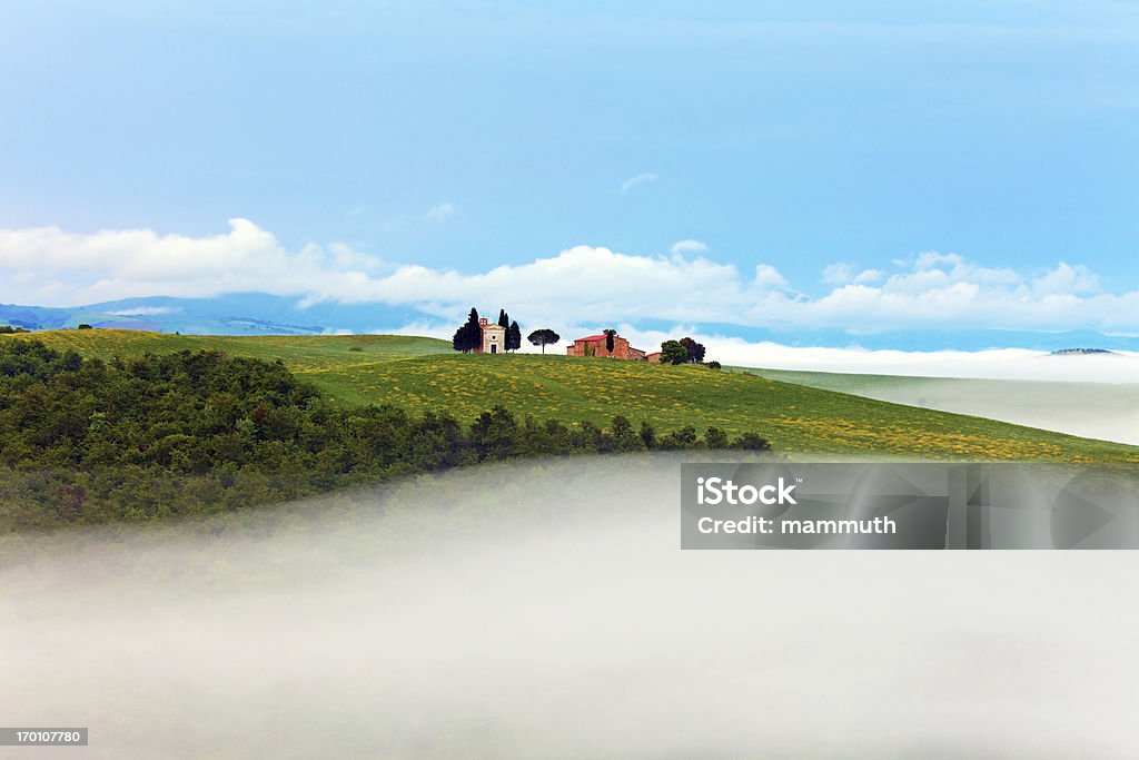 Small chapel in Tuscany Small chapel (Cappella di Vitaleta) in Val d'Orcia, Tuscany, Italy on a foggy morning. Agricultural Field Stock Photo