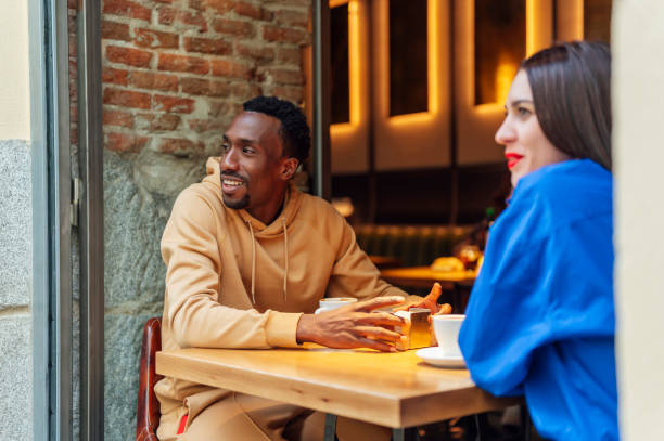 istock Two multi-ethnic friends enjoying a coffee together, sitting at a table 1701081096