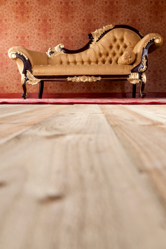 Low level view of an ornate chaise longue in an upper class drawing room.