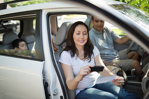 istock Women Using Smart Phone To Deposit Check In Car 170108366