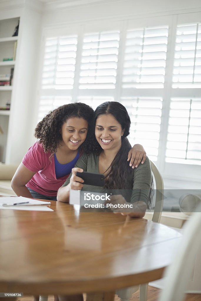 Chica con teléfono móvil y madre de banco múltiple de depósito - Foto de stock de 14-15 años libre de derechos