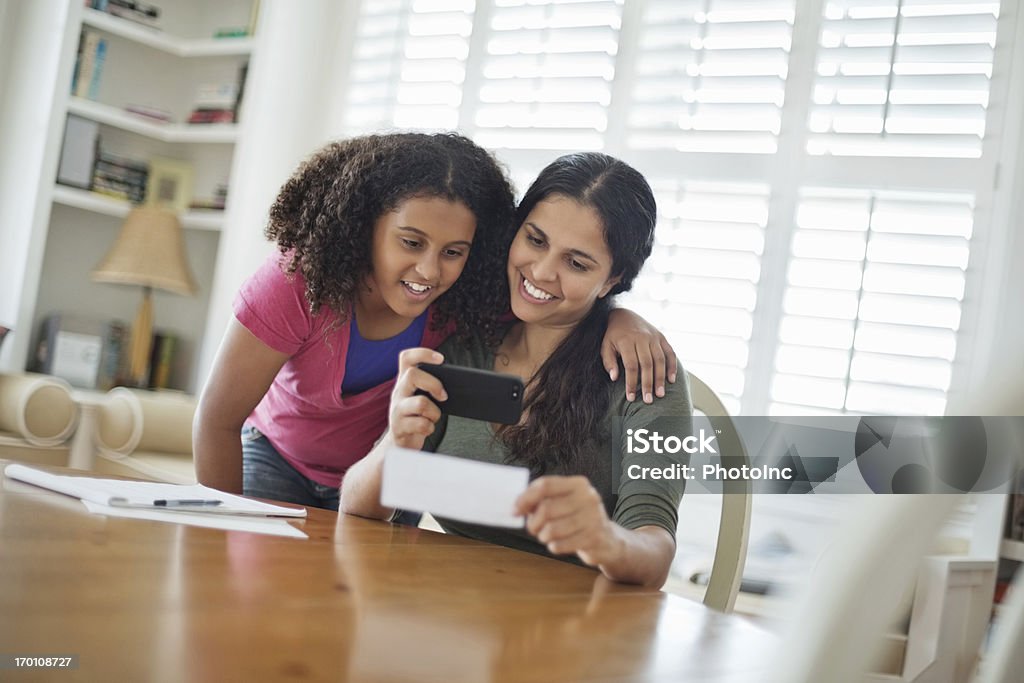 Tochter mit Mutter verrechnen von Bank Slip mit Handy - Lizenzfrei Handy Stock-Foto