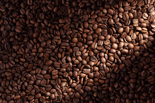 Paper cup of coffee latte and coffee beans on wooden table