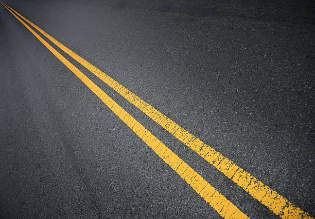 dobles líneas amarillas en el infinito - single line yellow road asphalt fotografías e imágenes de stock