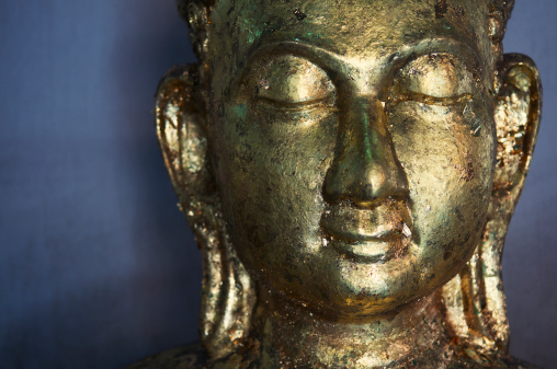 Golden Buddha closes his eyes in meditation 