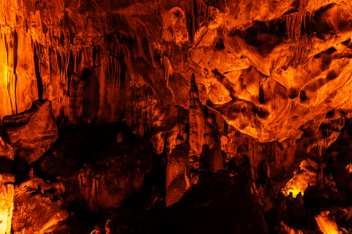 Background photo of the cave inside the mountain. Natural formations are visible in the illuminated cave. Abstract shapes were formed with the effects of shadow and light. Shot with a full frame camera.