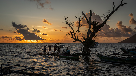 A beautiful sunset over Bunaken Island with the Manado Tua volcano in the background.