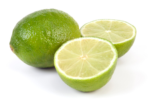 Sliced Lime and one whole on white background.  Selective focus, shallow DOF.