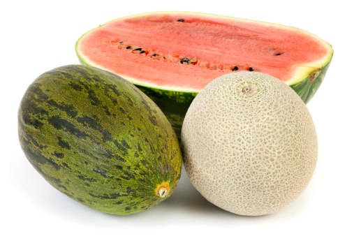 Whole Cantaloupe and Piel de Sapo with sliced watermelon on white background.