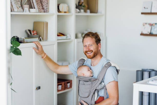 istock Small Business Owner with Baby in Store 1701129348
