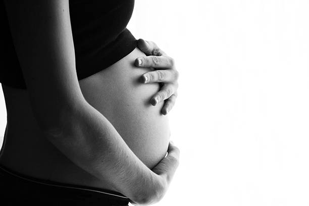 holding bauch - human pregnancy abdomen naked human hand stock-fotos und bilder