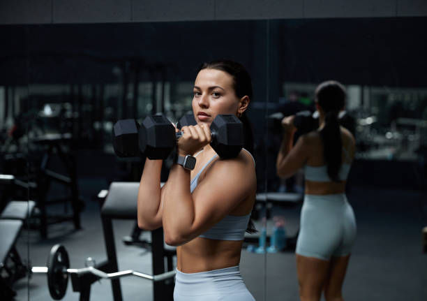 istock Strong sportswoman doing exercises with dumbbells 1701134556