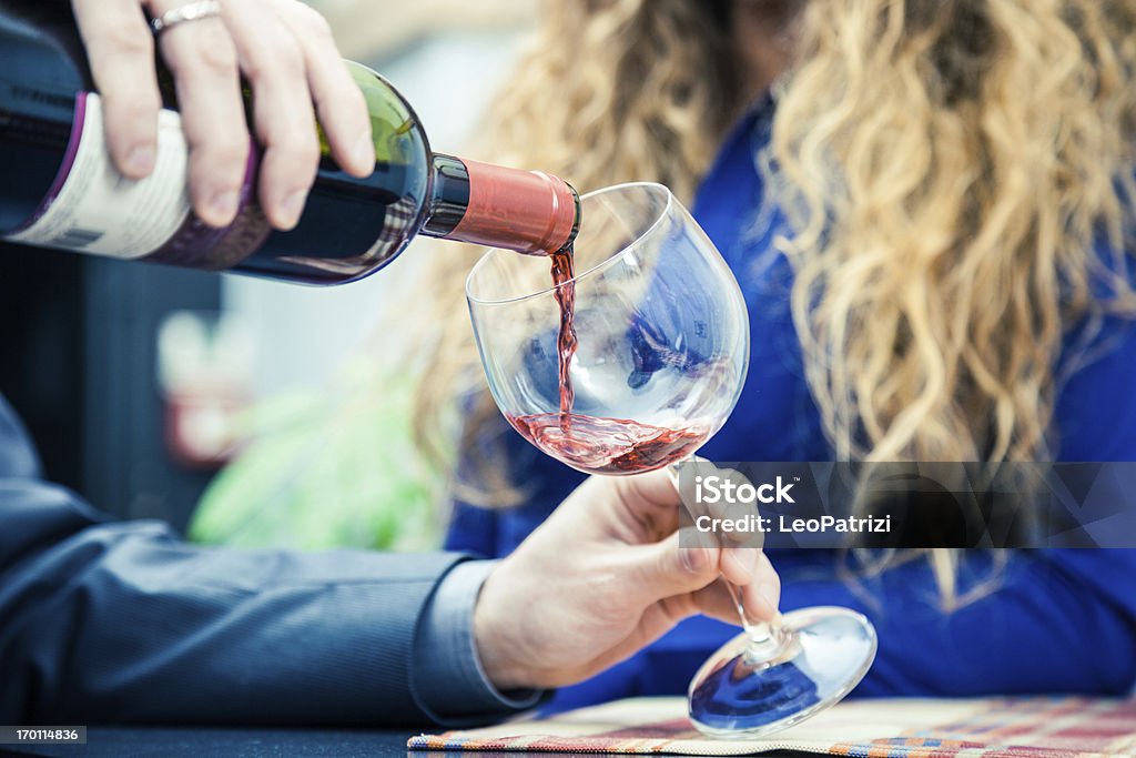 Versare il vino rosso durante l'Happy Hour - Foto stock royalty-free di Adulto