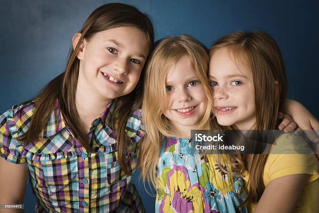 Trzy siostry, stojąc razem i objąć w domu - Zbiór zdjęć royalty-free (4 - 5 lat)