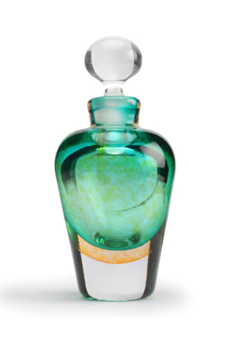 Coloured glass perfume bottle isolated on white.