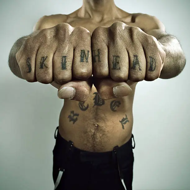 Photo of Skinhead Showing off Knuckle tattoo