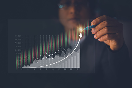 Businessman or investor point and analyze graph for trade stock market on virtual screen, candle stick chart graph and indicator stock trading, investment for success, digital assets, forex trading.