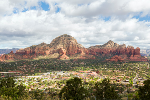 An early morning view of west Sedona, Arizona from above, with red rock formations in the background.