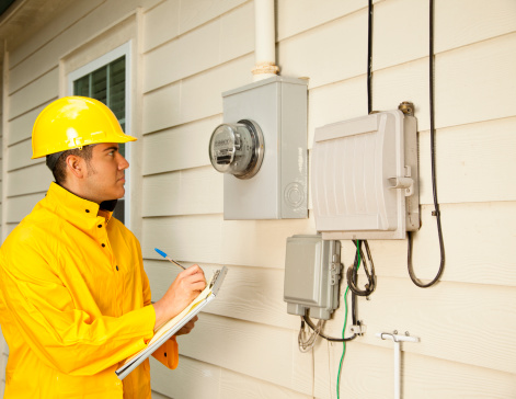 Electrician at outside electric meter on home
