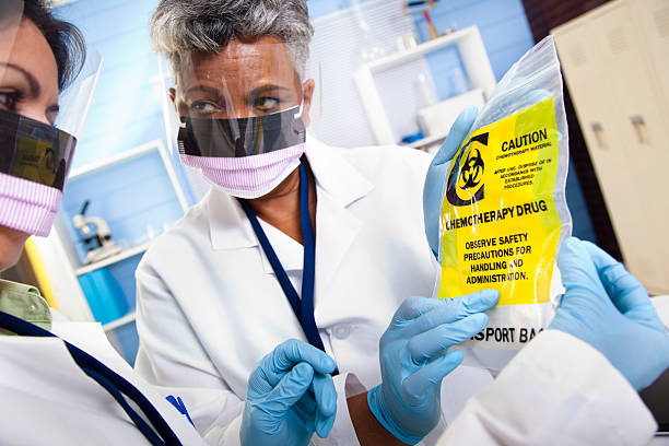 Multi-ethnic doctors discussing medical contents of chemotherapy bag Multi-ethnic doctors or scientists discussing medical contents of chemotherapy bag. chemotherapy drug stock pictures, royalty-free photos & images