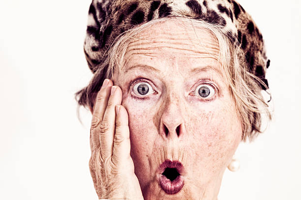 close up of senior woman wearing old fashioned fur hat surprised expression