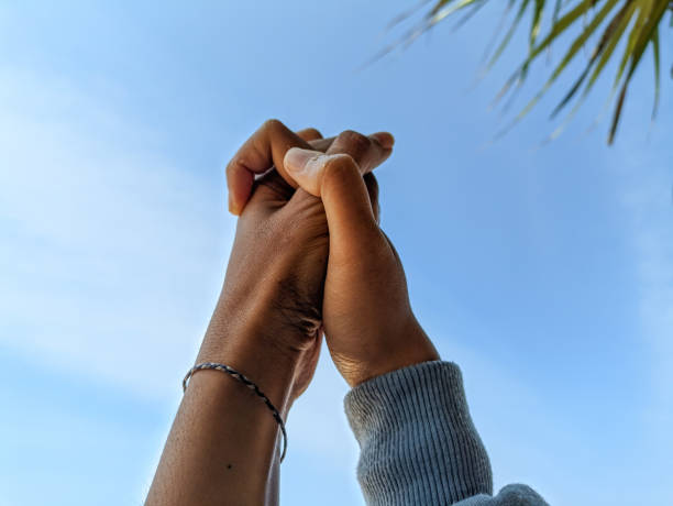 istock Holding hands against the blue sky. 1701241311