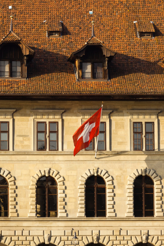 The Swiss Flag flies on an old stone building in the town of Lucerne (Luzern), Switzerland