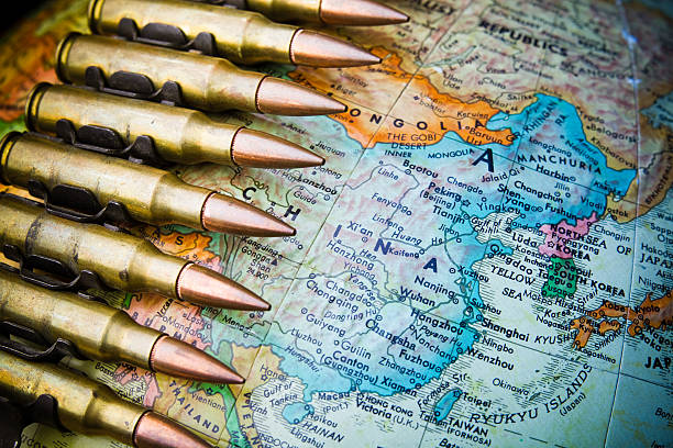 China at War Globe with China in focus and a bandolier of machine gun ammo draped across it. taiwan stock pictures, royalty-free photos & images