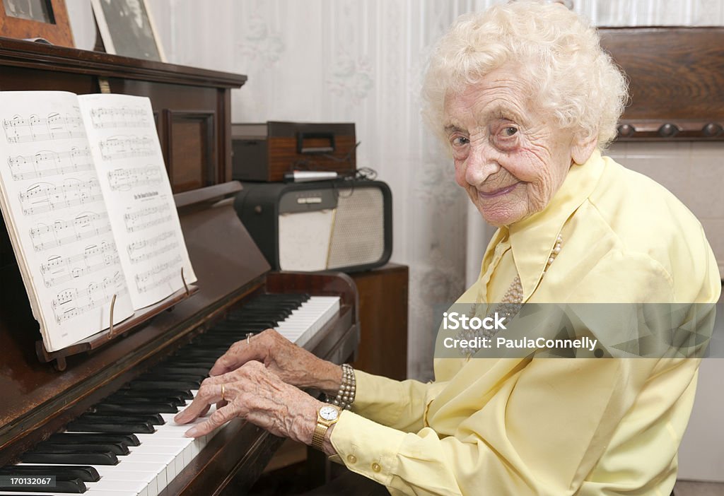 Пожилые леди играет на пианино дома - Стоковые фото Более 100 лет роялти-фри