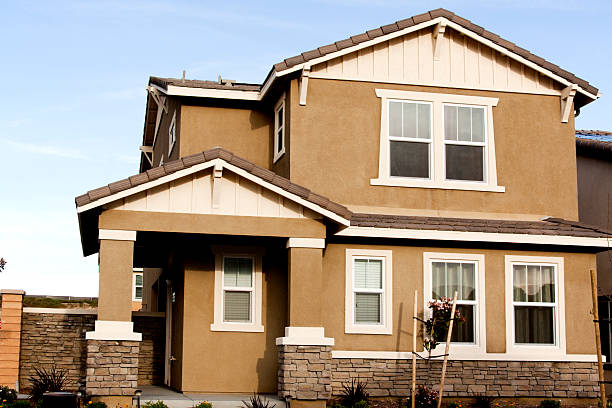 istock Brown stucco home with white trim against a blue sky 170132429