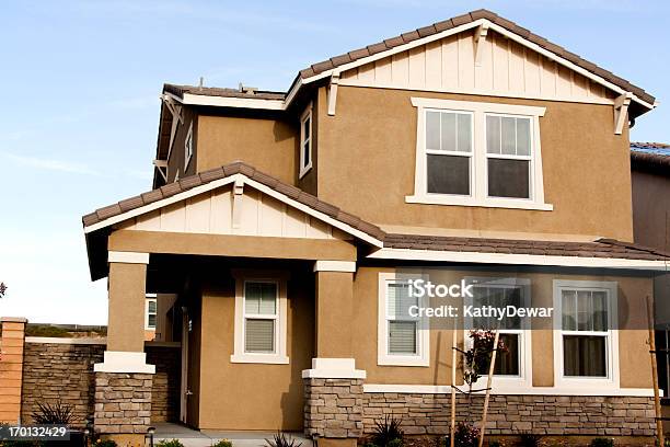 Brown Stucco Home With White Trim Against A Blue Sky Stock Photo - Download Image Now