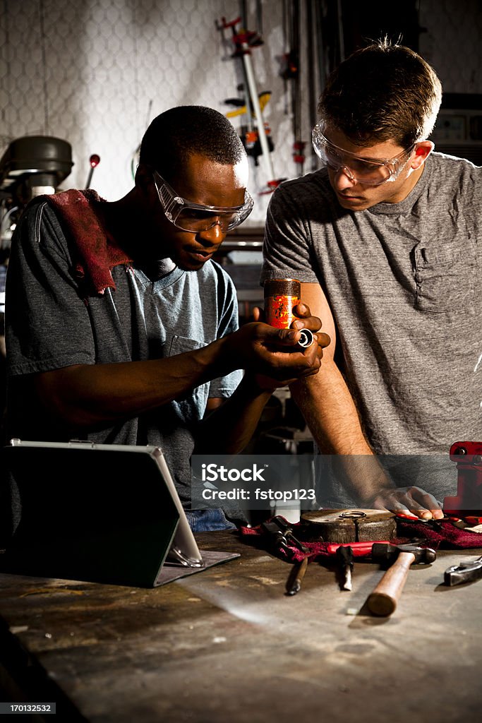 Мужчины на Рабочий стенд, используя планшетный компьютер для контроля деталей - Стоковые фото 20-24 года роялти-фри