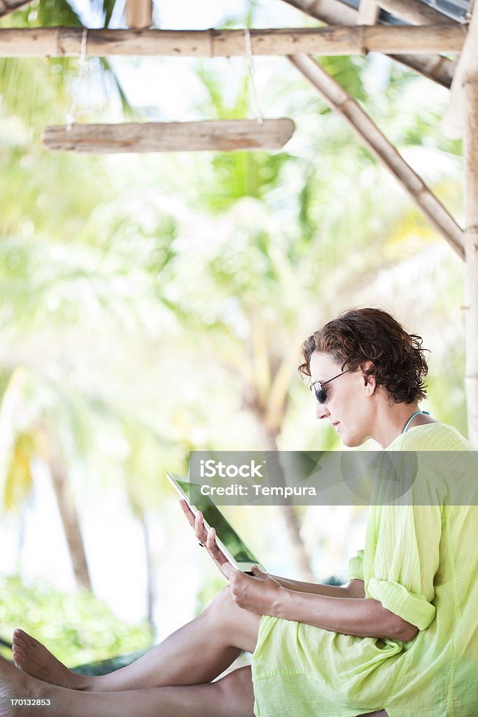 Женщина с помощью цифрового планшета в paradisiac пляж. - Стоковые фото 35-39 лет роялти-фри
