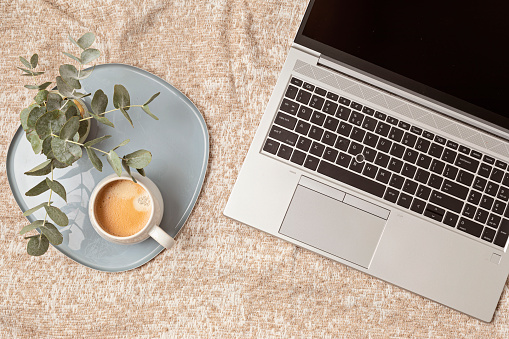 Flatlay with laptop on beige cover background. Flat lay, top view photo mock up