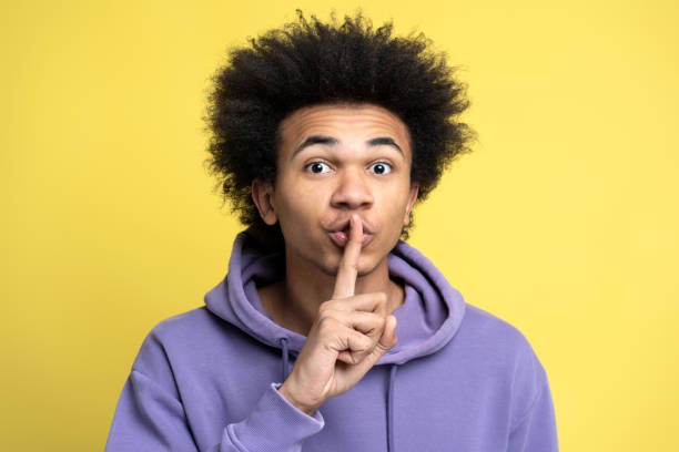 istock African American man looking at camera with silent sign 1701338938