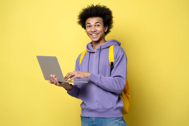 istock Young African American man using laptop computer, watching videos 1701339037