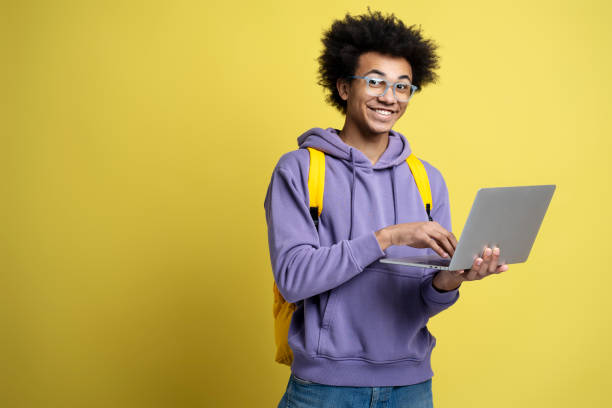istock Young African American man using laptop computer, watching videos 1701339145