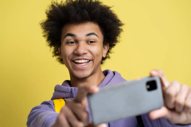 istock Cheerful African American man using smartphone making selfie 1701339470