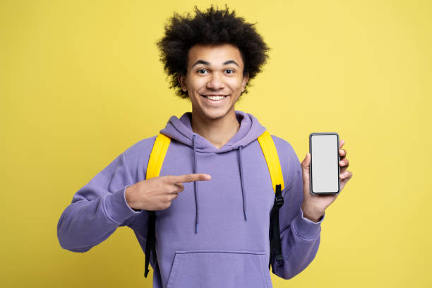 istock Amazed african american guy pointing finger, showing to camera smartphone 1701339480