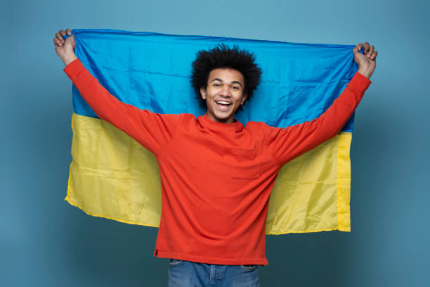 istock Excited man holding Ukrainian flag isolated on blue background 1701339533