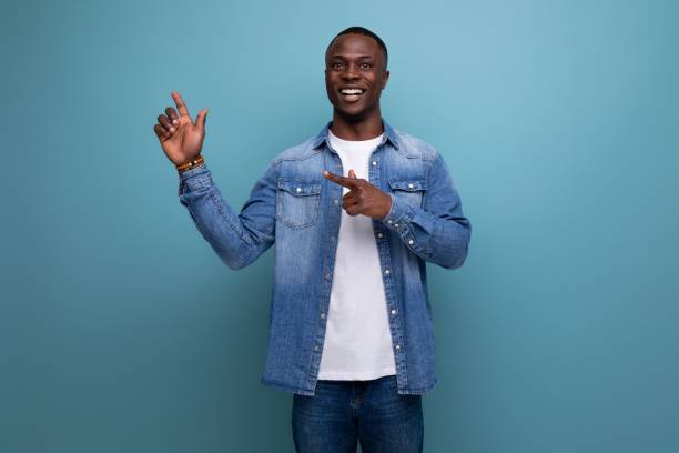 istock handsome young attractive african man dressed casually in denim clothes actively gesturing with his hands pointing at an idea 1701347202