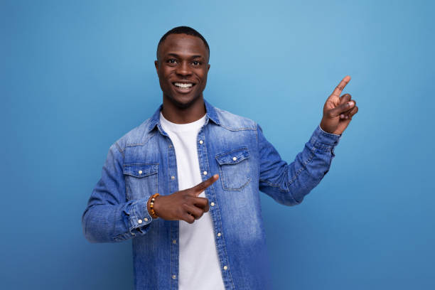 istock handsome young attractive african man dressed casually in denim clothes actively gesturing with his hands pointing at an idea 1701347206