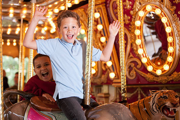 niños montando carrusel - carousel merry go round child african descent fotografías e imágenes de stock