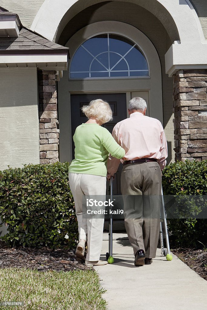 Coppia Senior davanti a casa, utilizzando Deambulatore - Foto stock royalty-free di Pazienza