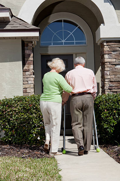 istock Senior couple in front of house, using walker 170137879
