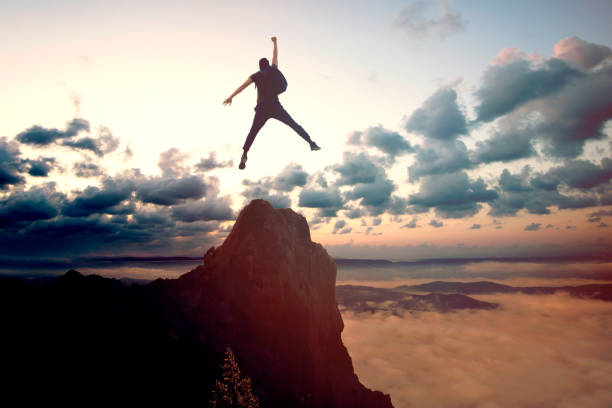 istock Businessman Jumping on Mountain Peak 1701412519