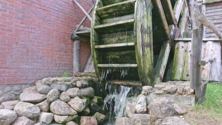 Wooden mill wheel rotates under water pressure, slow motion video